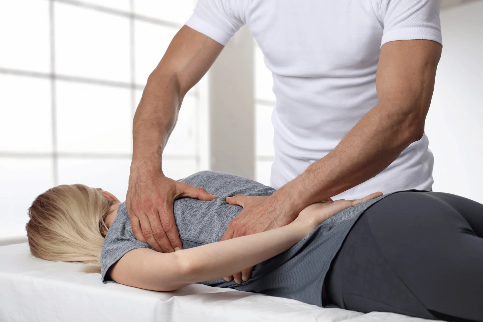 Chiropractor assessing a patient’s spine before an adjustment at Aligned Health in Laguna Hills