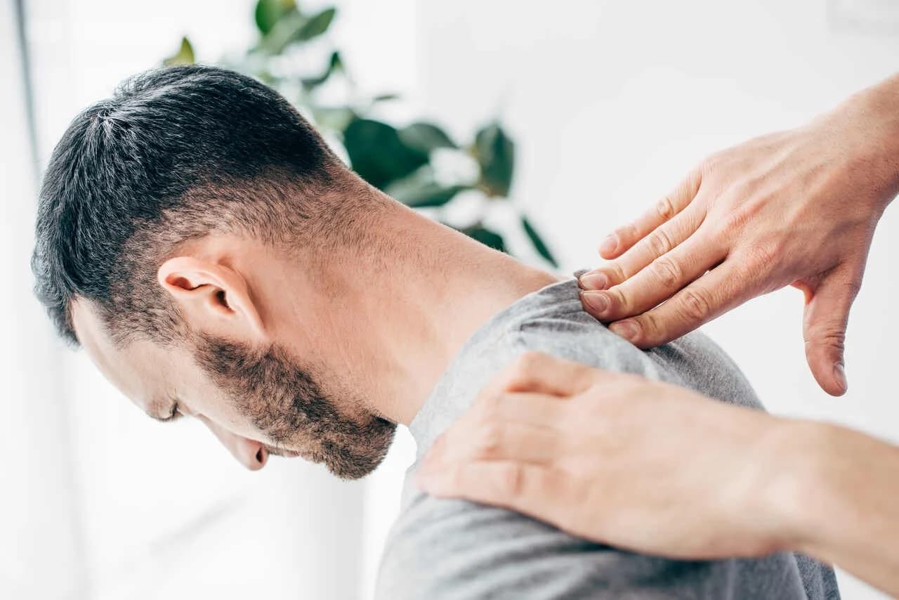 Chiropractor examining a patient's neck and shoulder at Aligned Health in Laguna Hills